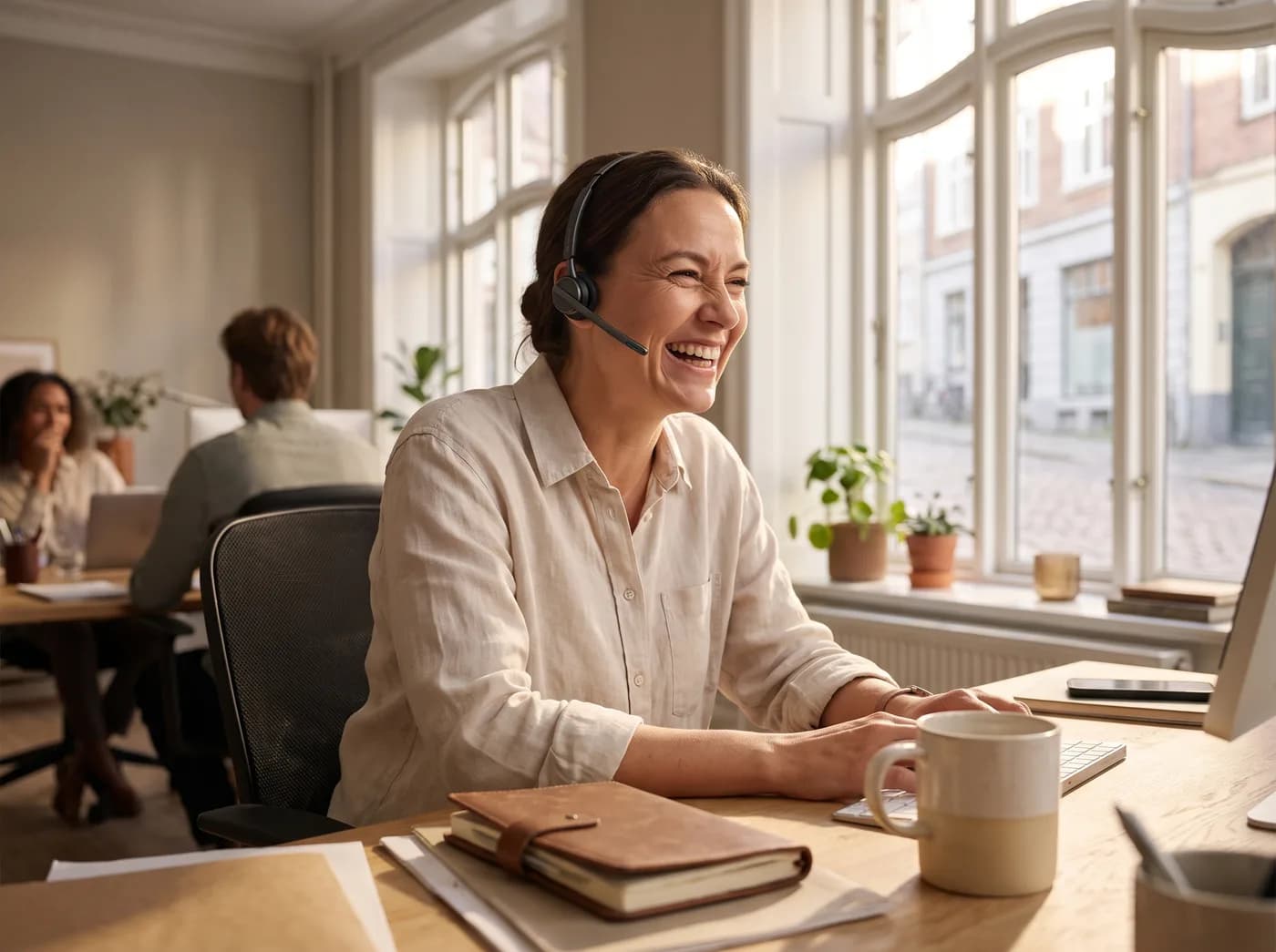 A support specialist smiling during a friendly call at a desk