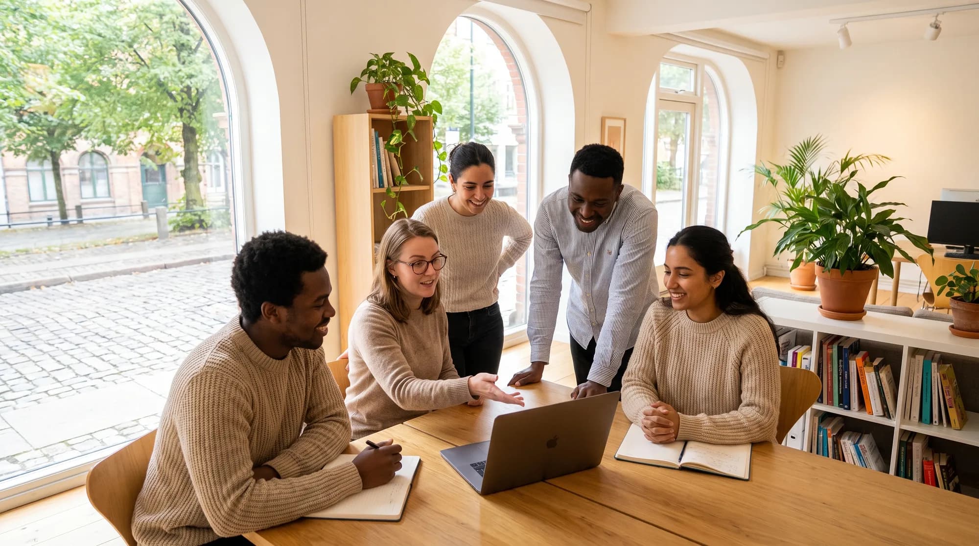 A support team gathered around a laptop in a relaxed planning session