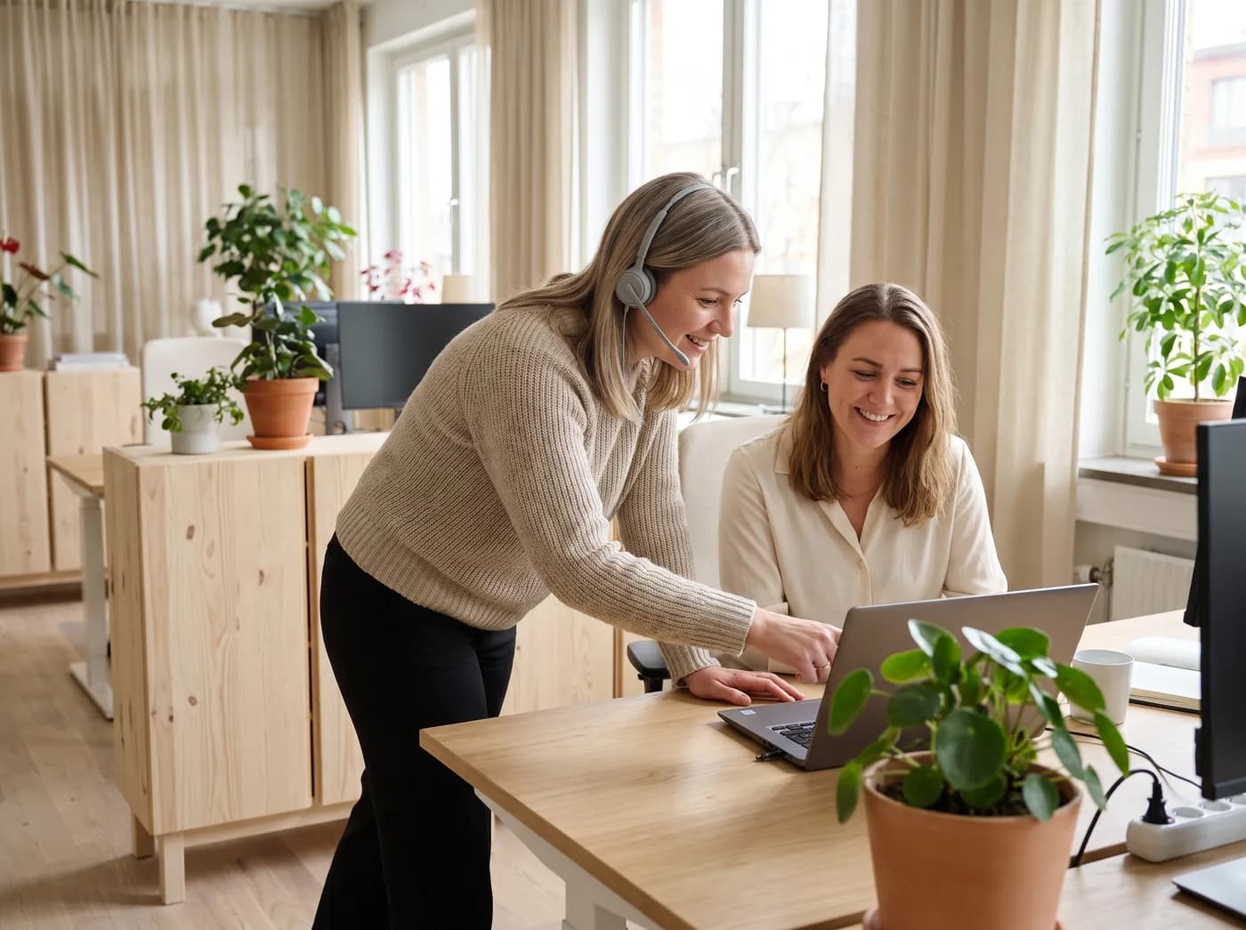 A specialist guiding a colleague through a setup on a laptop